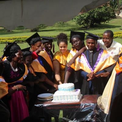 Graduates of the part 6, 19th Graduation ceremony cut cake with STM's Executive director, Deborah Menssah(in orange)